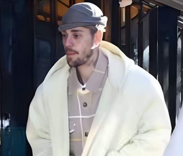 A man in a white coat and hat walking along the street, associated with Justin Bieber collaborations